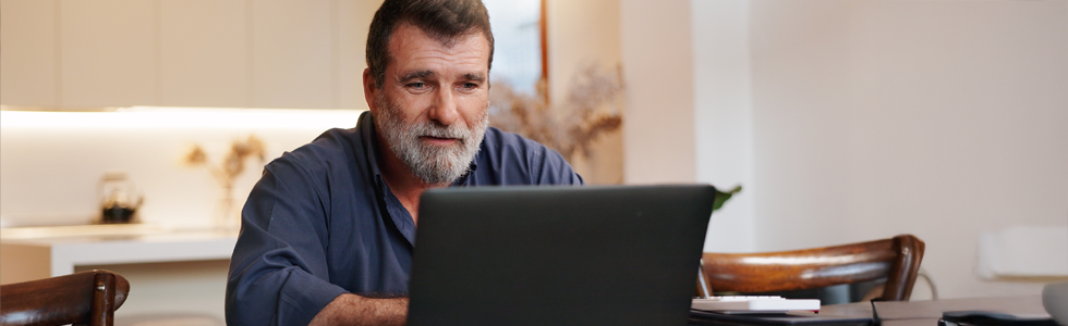 A man looks at his laptop at home, and tries to sort his legal problem